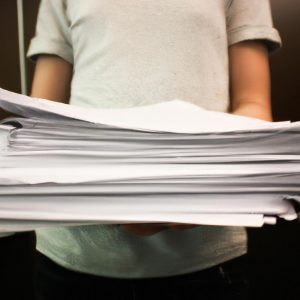Person holding a stack of papers